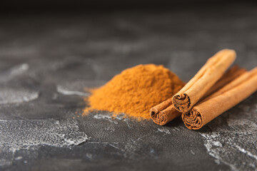 Ceylon cinnamon.Cinnamon sticks on a textured wooden background. Cinnamon roll and powder. Spicy...