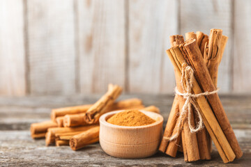 Ceylon cinnamon.Cinnamon sticks on a textured wooden background. Cinnamon roll and powder. Spicy spice for baking, desserts and drinks. Fragrant ground cinnamon. Close-up. Place for text. copy space
