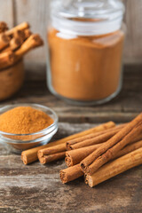 Ceylon cinnamon.Cinnamon sticks on a textured wooden background. Cinnamon roll and powder. Spicy spice for baking, desserts and drinks. Fragrant ground cinnamon. Close-up. Place for text. copy space