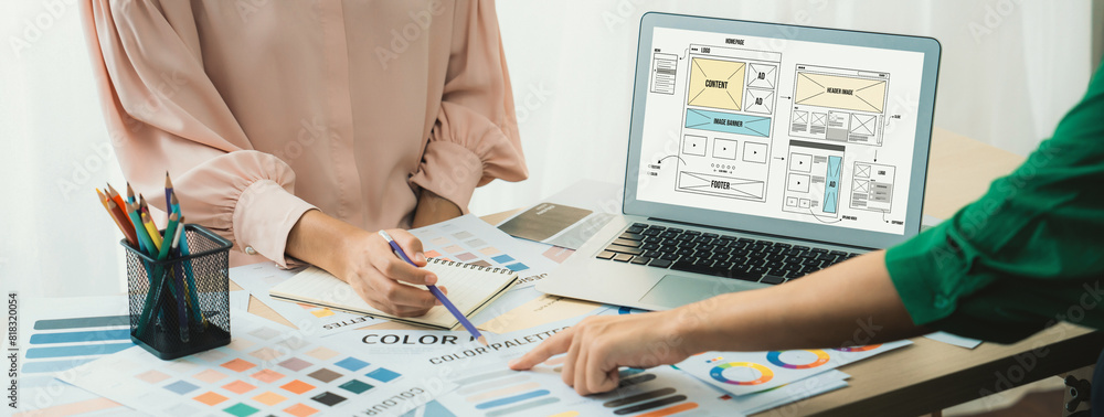 Poster cropped image of interior designer presents color from color swatches while laptop displayed website