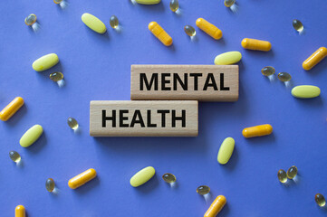 Mental Health symbol. Concept word Mental Health on wooden blocks. Beautiful purple background with...