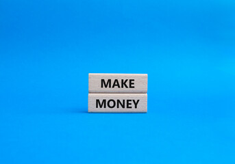 Make Money symbol. Wooden blocks with words Make Money. Beautiful blue background. Business and...