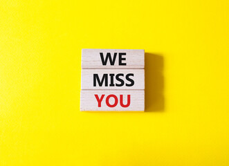 We Miss you symbol. Concept words We Miss you on wooden blocks. Beautiful yellow background....