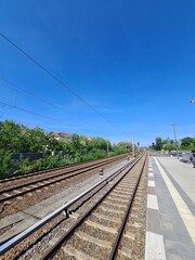 Bahngleise mit blauem Himmel an der Bahnhaltestelle Baumschulenweg in Berlin, Treptow/Köpenick