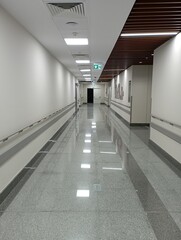 Empty modern hospital corridor, clinic hallway interior background with white chairs for patients waiting for doctor visit. Contemporary waiting room in medical office. Healthcare services concept