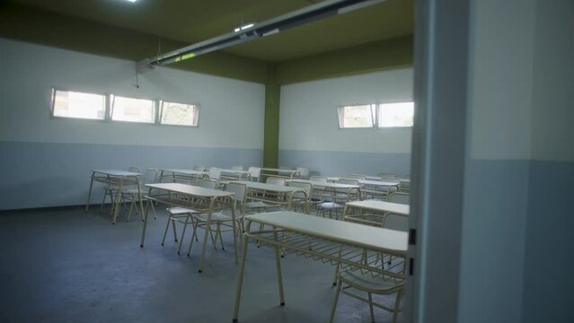 Aula de escuela o colegio con pupitres y bancos nuevos blancos.