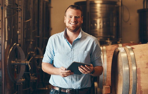 Portrait, man and smile with tablet in brewery as manager with pride on product, process and schedule for supplier. Business, barrel and happy for beer production, manufacturing or craft in factory