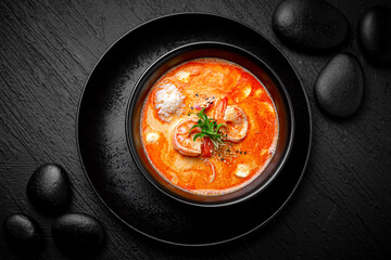 Composition of tom yam soup with shrimp and rice on black background. The Art of Japanese Cuisine....