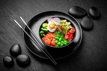 Salmon Poke bowl composition on black background. The Art of Japanese Cuisine. Food photography for menu and sushi bar decoration