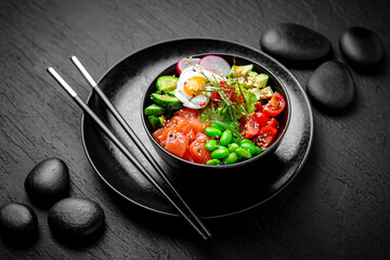 Salmon Poke bowl composition on black background. The Art of Japanese Cuisine. Food photography for menu and sushi bar decoration
