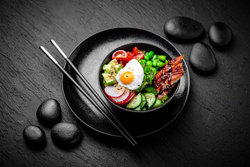 Smoked Eel Poke bowl composition on black background. The Art of Japanese Cuisine. Food photography...