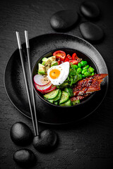 Smoked Eel Poke bowl composition on black background. The Art of Japanese Cuisine. Food photography for menu and sushi bar decoration
