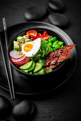 Smoked Eel Poke bowl composition on black background. The Art of Japanese Cuisine. Food photography for menu and sushi bar decoration