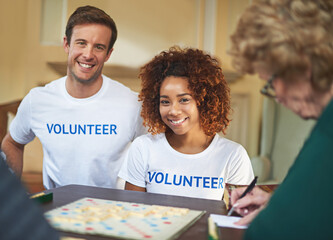 Volunteers, happy and portrait with senior people in retirement home, board game and social...