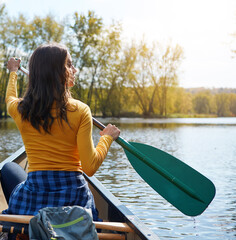 Woman, back and canoeing in nature on lake, wellness hobby and backpack for supplies with paddle...