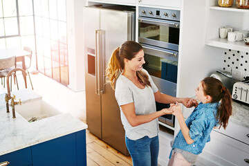 Happy, girl and child dance in kitchen with love, care and support in family or home on weekend....