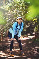 Tired, runner and woman hiking in nature on trail or outdoor adventure to explore on holiday...