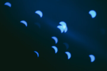Abstract blue shapes resembling crescent moons on dark background