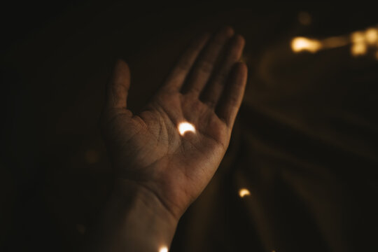 Softly illuminated hand capturing a glimpse of light