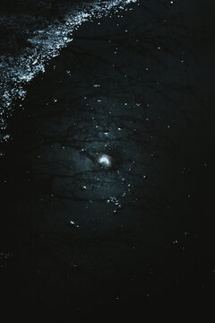 Dark water surface with reflections under moonlight