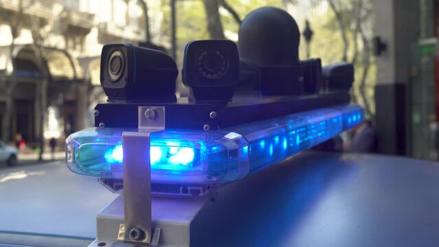 Sirena de polic&iacute;a con c&aacute;maras de seguridad en la ciudad un d&iacute;a soleado. Gente circulando en la ciudad. Patrulla de polic&iacute;a.