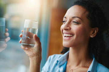 Woman, smile and home with water in glass for wellness, wellbeing and hydration. Happy, female...