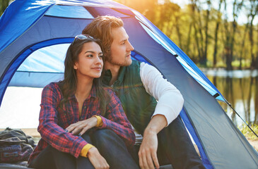 Couple, thinking and camping outdoor to relax with love and happiness together on adventure in woods. People, smile or journey in nature with peace on holiday, vacation or travel in forest at river