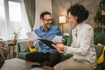 Obraz premium Two colleagues man and woman work on economy project together at home