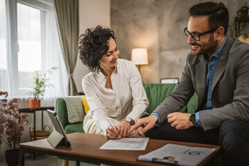 Mature woman sign insurance or contract to adult man at home