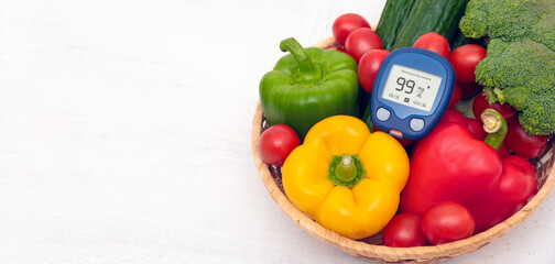 Diabetes diet, glucometer and vegetables on table
