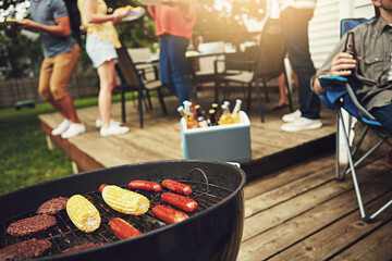 Food, barbecue and outside on weekend with grill for corn, sausage and cooking burgers in backyard....