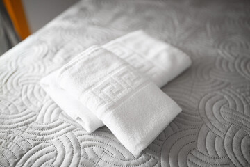 Clean towel on the bed in the modern interior of hotel bedroom