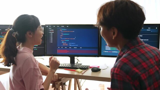 Slow motion back end software developer engineer for computer programming working together on debugging writing computing code, solving complex algorithms display on monitor in office. Burgeoning