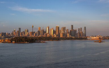 Obraz premium Extraordinary view of Sydney's Icons, namely the Sydney Opera House, Sydney Harbor Bridge and Sydney Downtown, while arriving by cruise ship in a beautiful sunrise.