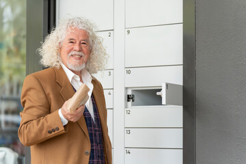 Older man with a package at a locker, wearing a brown jacket and vest
