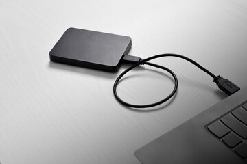 External backup hard disk drive connected to laptop on white background. external hard disk connect by USB 3.0 port to laptop