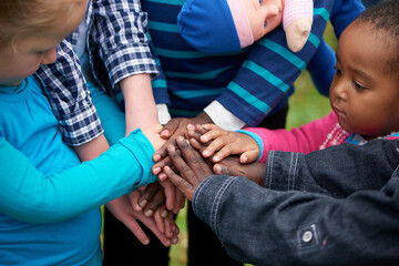 Hands, huddle and volunteer with children in park together for humanitarianism, charity and...