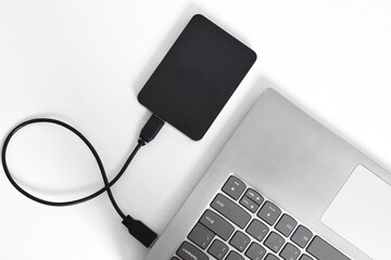 External backup hard disk drive connected to laptop on white background. external hard disk connect by USB 3.0 port to laptop