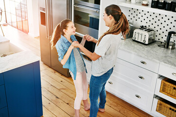 Happy, girl and mom dance in kitchen with love, care and support in family or home on weekend. Excited, energy and mother relax with child in morning or bonding with joy or holding hands from above