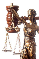 statue Themis representing justice and fairness with the judge mallet gavel unfocused in background