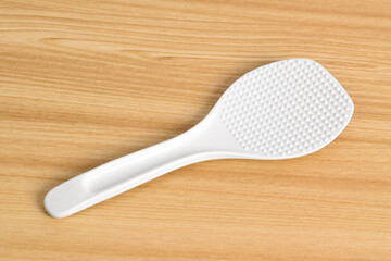 White rice spoon or rice ladle on wooden table. White plastic rice paddle