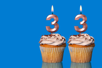 Birthday Cupcakes With Candles Lit Forming The Number 33.