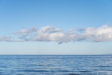 Peaceful, serene, and calming blue nature background of flat Pacific Ocean reaching to a blue sky...