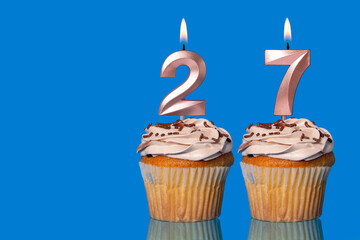 Birthday Cupcakes With Candles Lit Forming The Number 27.