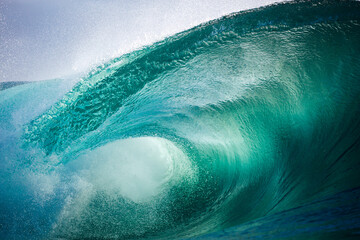 Beautiful jade colored ocean wave breaking over a shallow reef