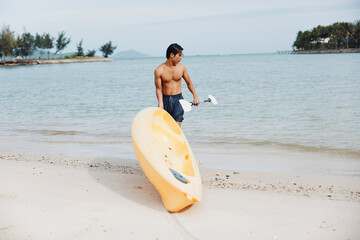 Happy Asian Man Kayaking on Tropical Beach: Summer Vacation Fun
