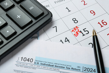 Calendar with date reminder about tax day, documents, pen and calculator, closeup