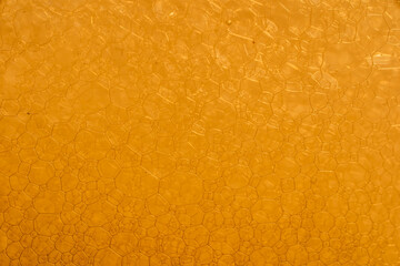 Closeup macro shot of foam bubbles in yellow water