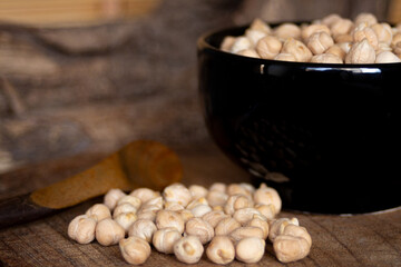 Chickpeas beans in black bowl . Still life.Blurred background.Still life