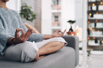 Mudra, hand and meditation on sofa in home for chakra connection, balance and mental health in...